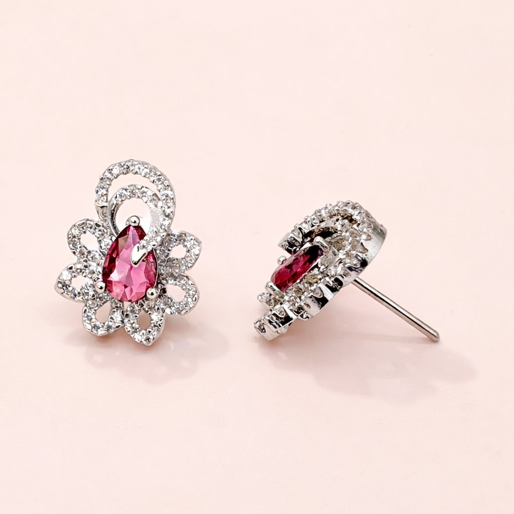 Pair of AD Earrings for Women with pink gemstones on a light pink background