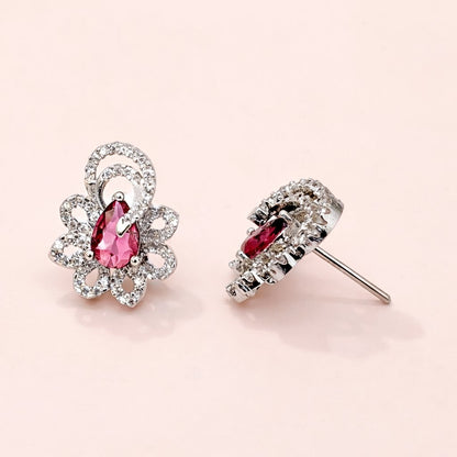 Pair of AD Earrings for Women with pink gemstones on a light pink background