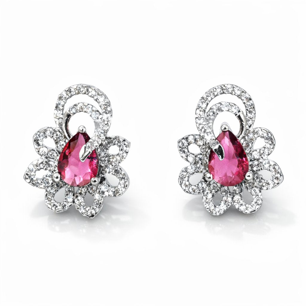 Pair of earrings with pink gemstones and silver floral designs on a white background