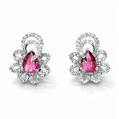 Pair of earrings with pink gemstones and silver floral designs on a white background