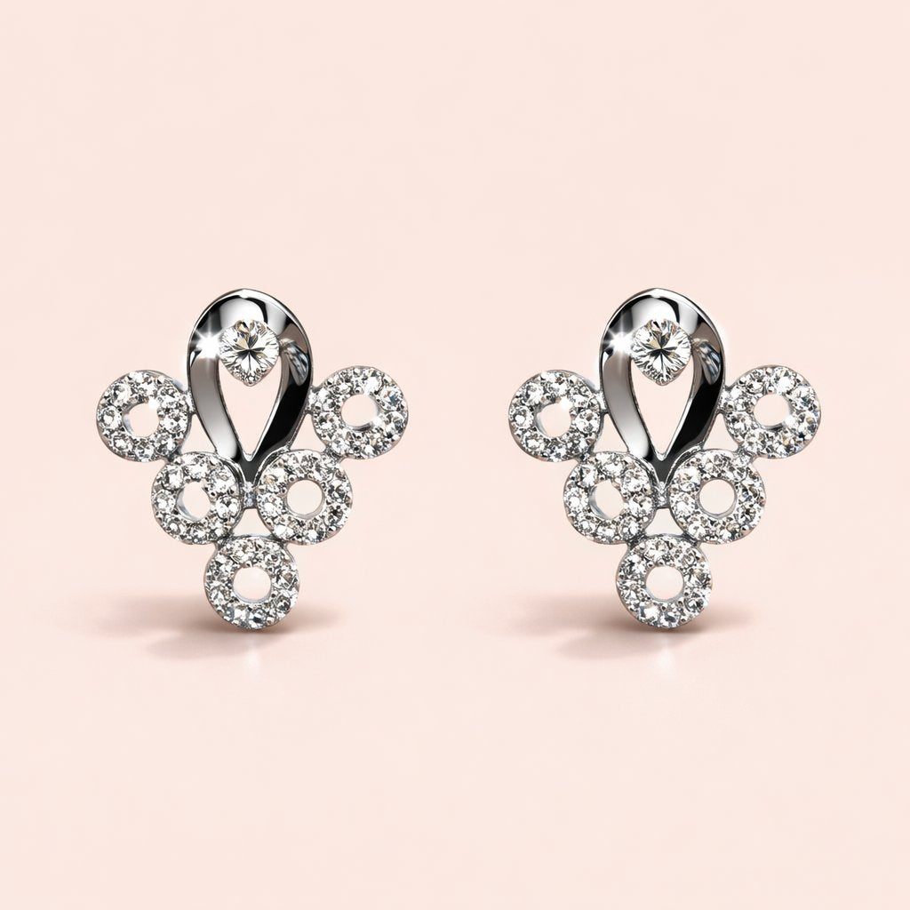 Pair of silver AD Earrings for Women with circular designs on a light pink background