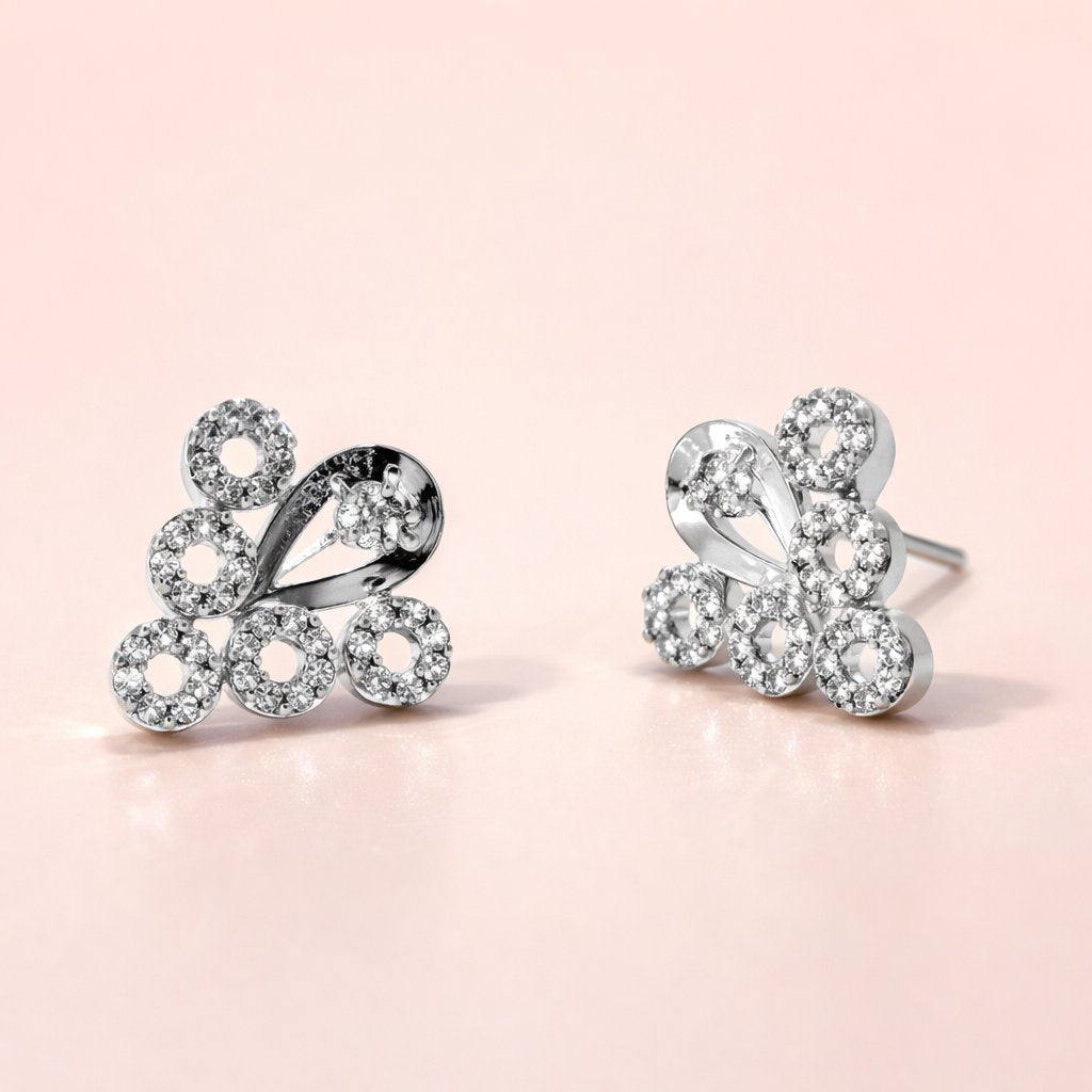 Butterfly-shaped silver AD Earrings for Women with clear gemstones on a pink background