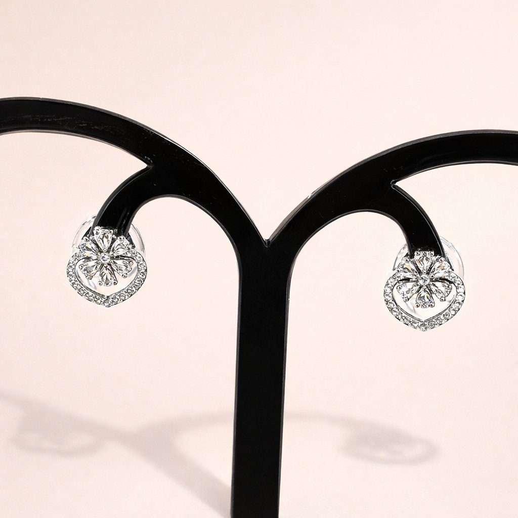Heart-shaped diamond AD Earrings for Women on a black stand with a soft pink background