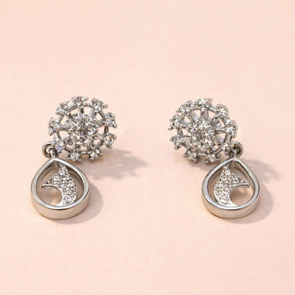Pair of silver AD Earrings for Women with intricate designs on a light pink background
