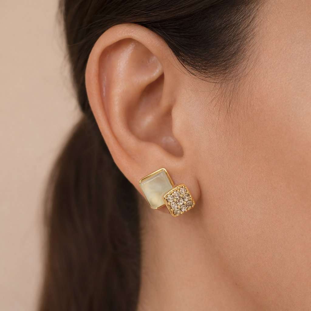 Gold and green AD Earrings for Women worn by a person with a neutral background