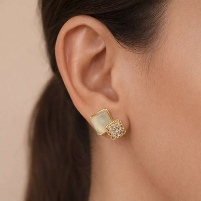 Gold and green AD Earrings for Women worn by a person with a neutral background