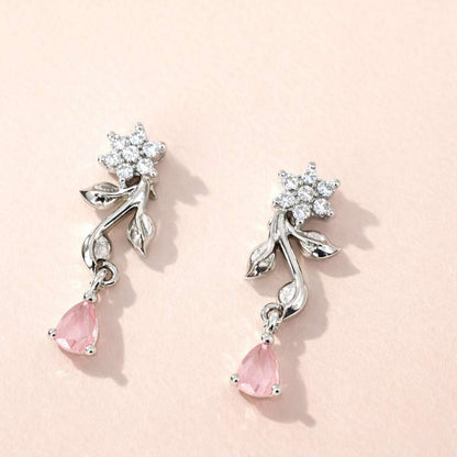 Pair of AD Earrings for Women with pink teardrop stones and silver floral designs on a light pink background