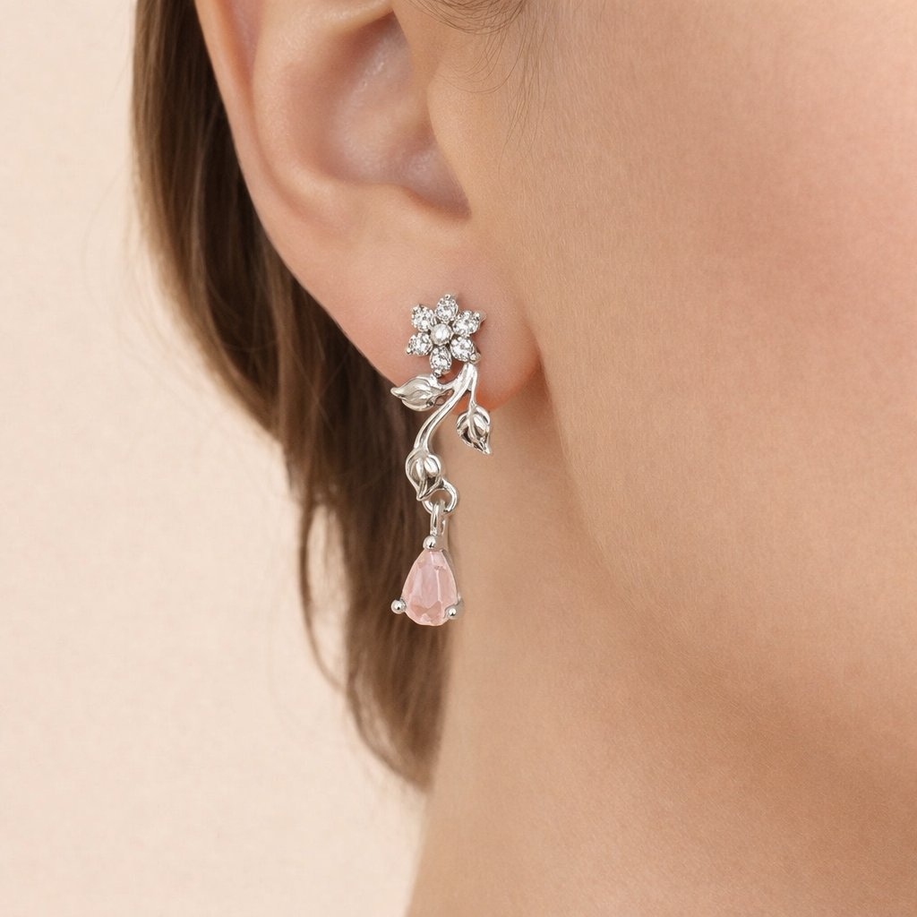 AD Earrings for Women with pink teardrop and floral design worn by a person on a beige background