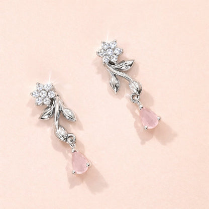 Silver AD Earrings for Women with pink gemstones on a light pink background