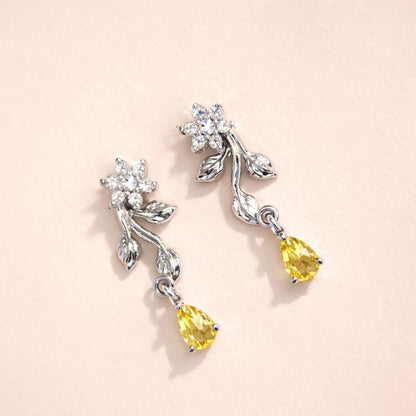 Silver AD Earrings for Women with yellow gemstones on a light pink background