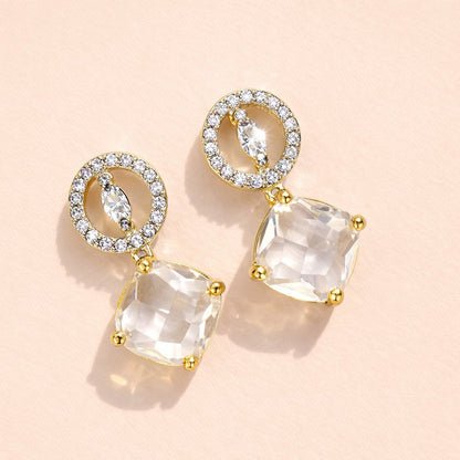 Gold AD Earrings for Women with clear gemstones on a beige background
