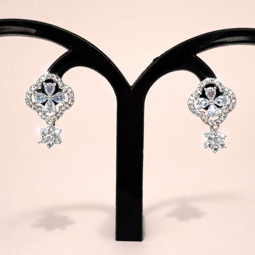 Pair of diamond AD Earrings for Women on a black stand against a pink background