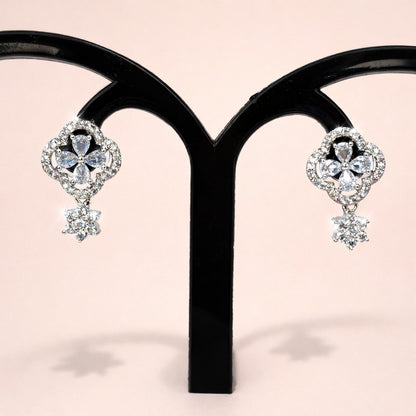 Pair of diamond AD Earrings for Women on a black stand against a pink background