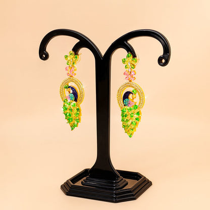 Pair of ornate AD Earrings for Women on a black stand against a beige background