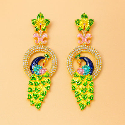 Pair of silver AD Earrings for Women with green gemstones on a white background