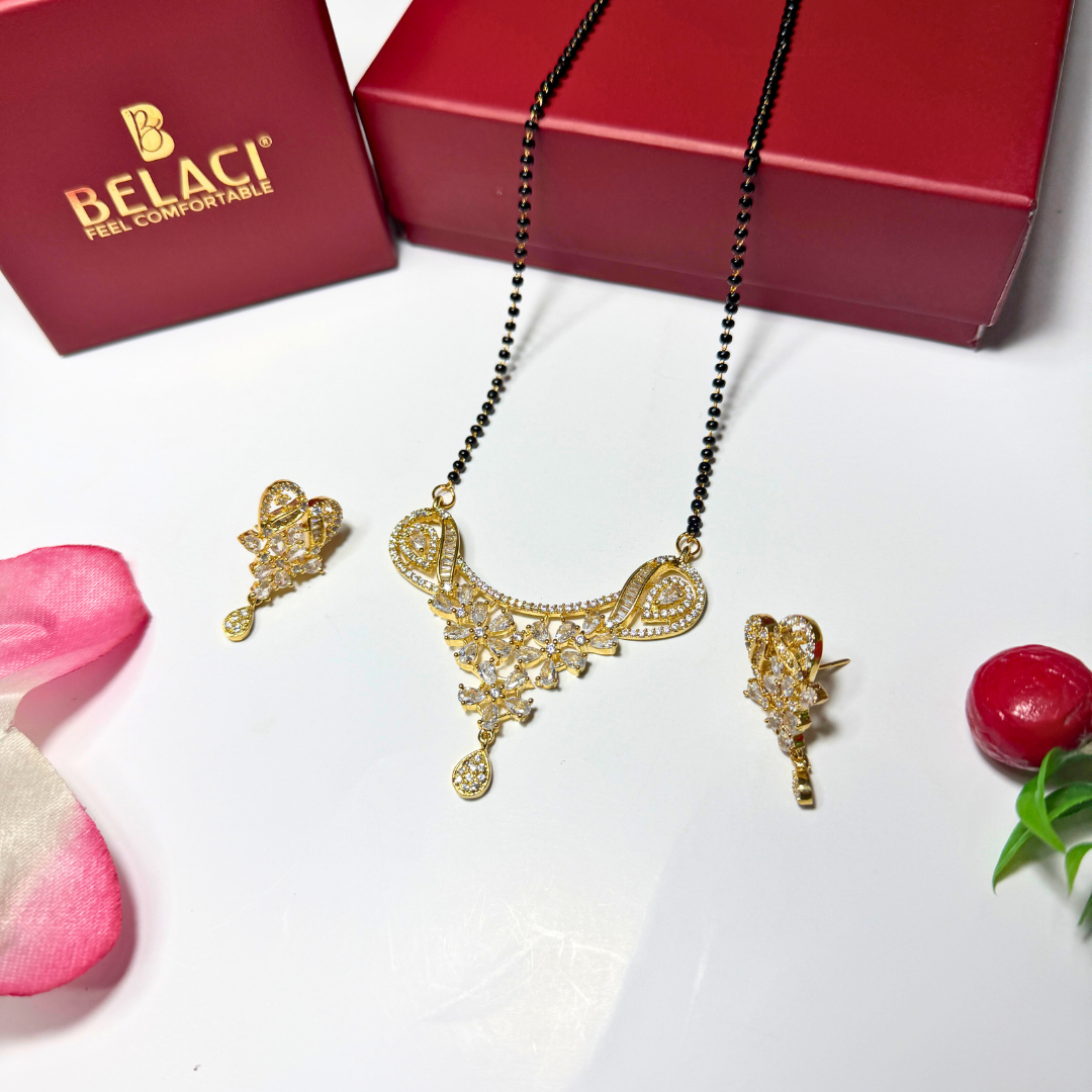 Gold AD Mangalsutra with matching earrings on a white surface with a Belaci box in the background.
