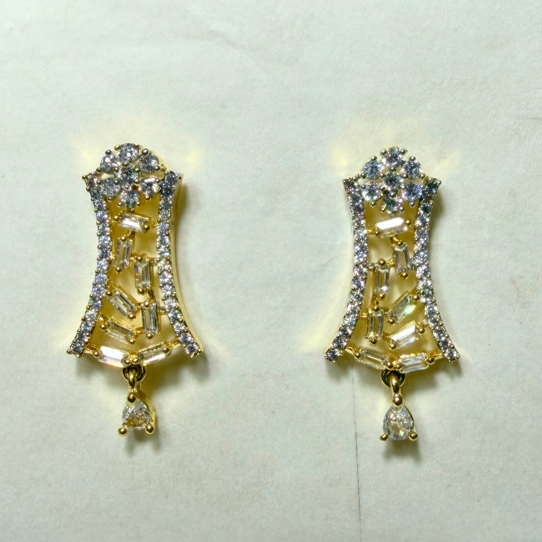 Gold AD earrings with clear gemstones on a light gray background