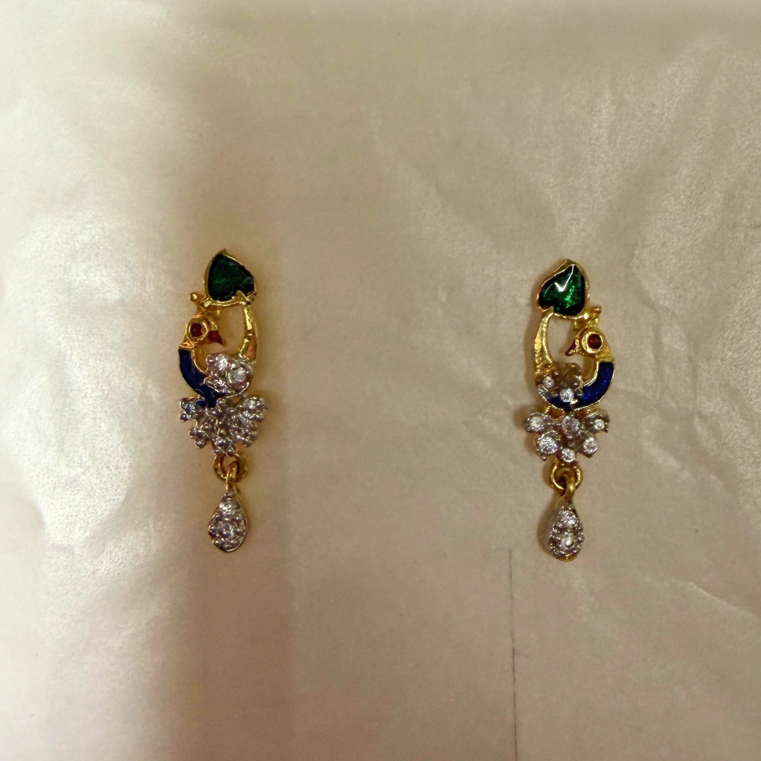 Pair of gold AD Mangalsutra with gemstones on a beige background