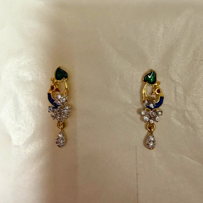 Pair of gold AD Mangalsutra with gemstones on a beige background