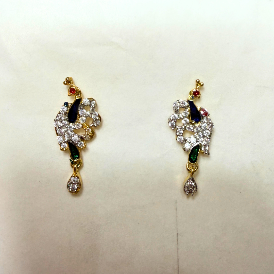 Pair of ornate AD earrings with gemstones on a light background