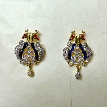 Pair of ornate AD earrings with intricate designs on a light background