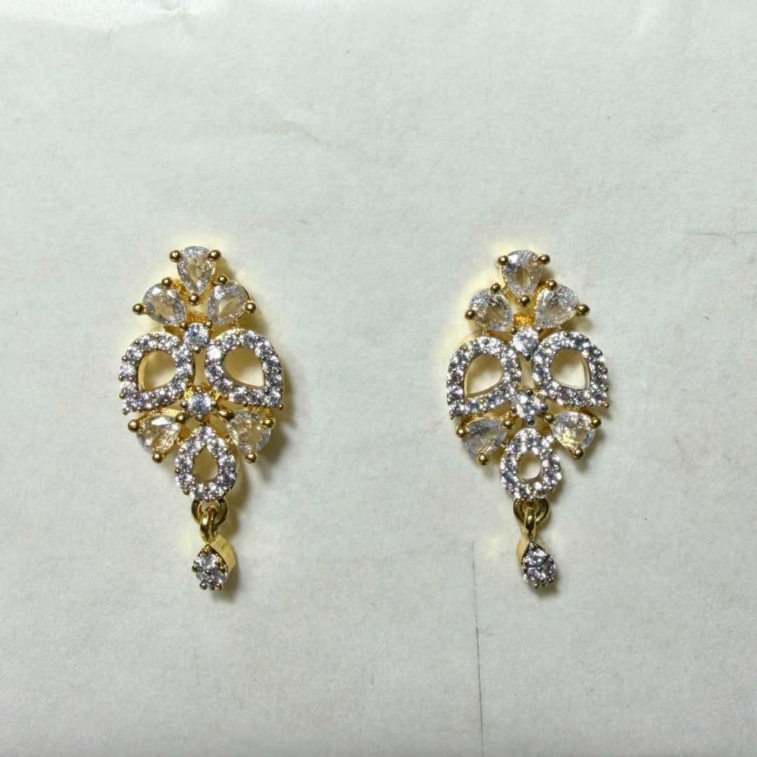 Gold and diamond AD earrings on a light background