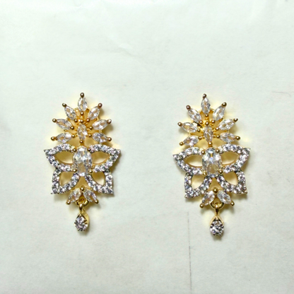 Gold and crystal AD earrings on a light background