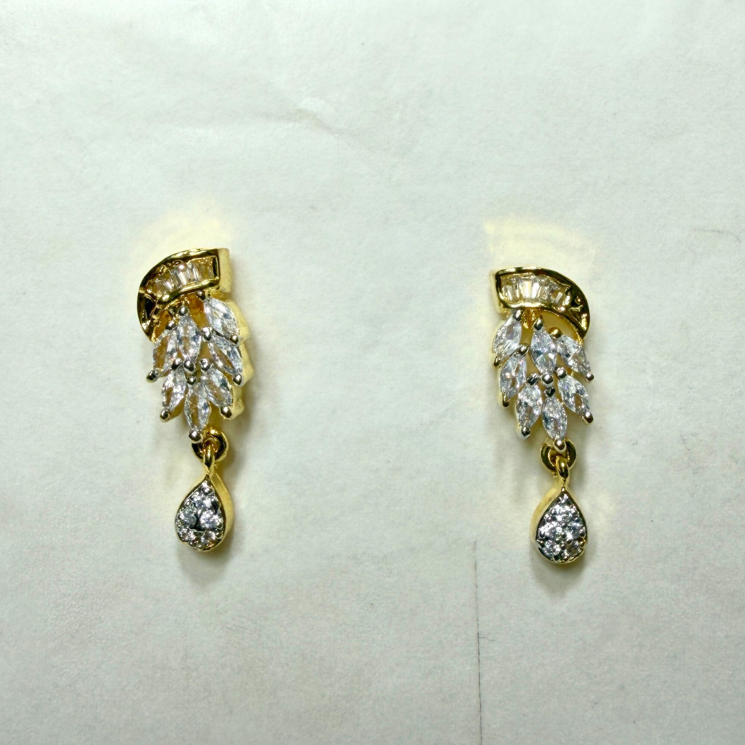 Pair of gold and diamond AD earrings on a light gray background