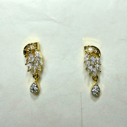 Pair of gold and diamond AD earrings on a light gray background