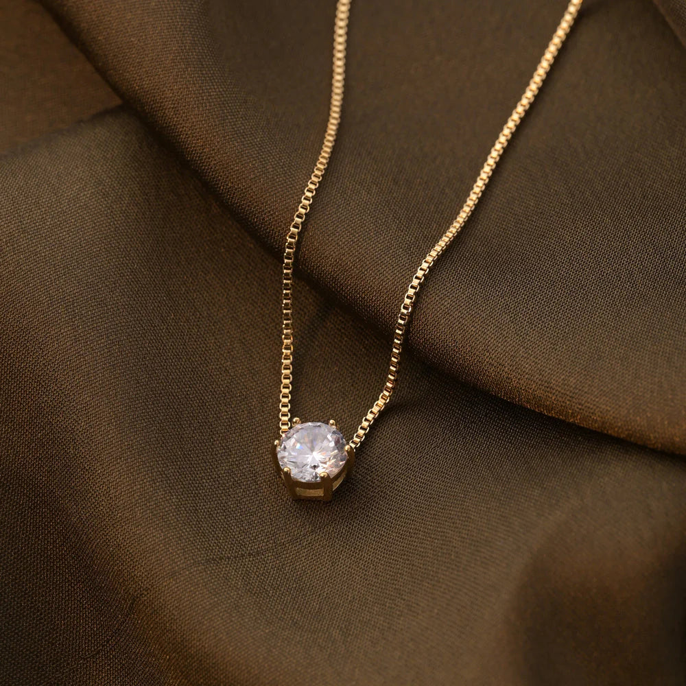 Gold Plated necklace with a diamond pendant on a brown fabric background
