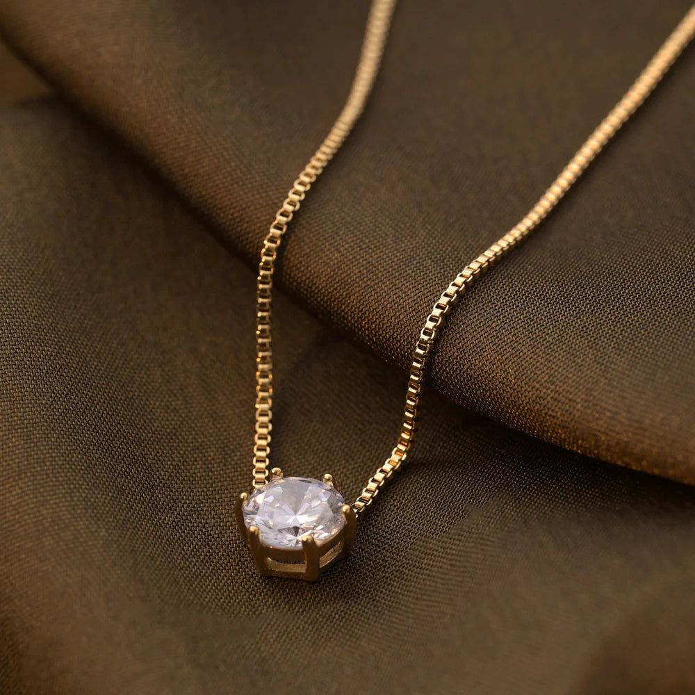 Gold Plated necklace with a diamond pendant on a brown fabric background