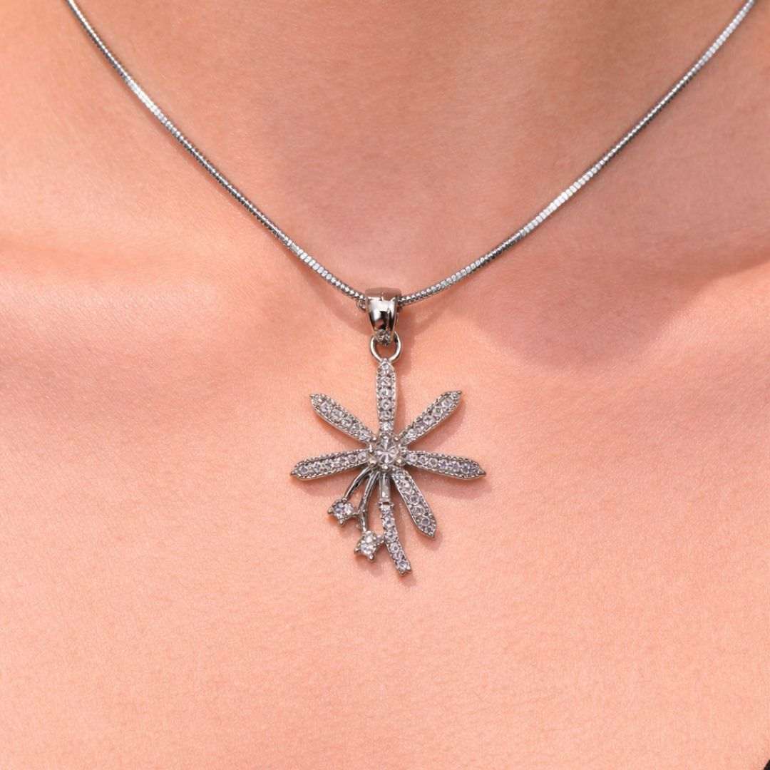 Silver necklace with a star-shaped pendant on a person's neck