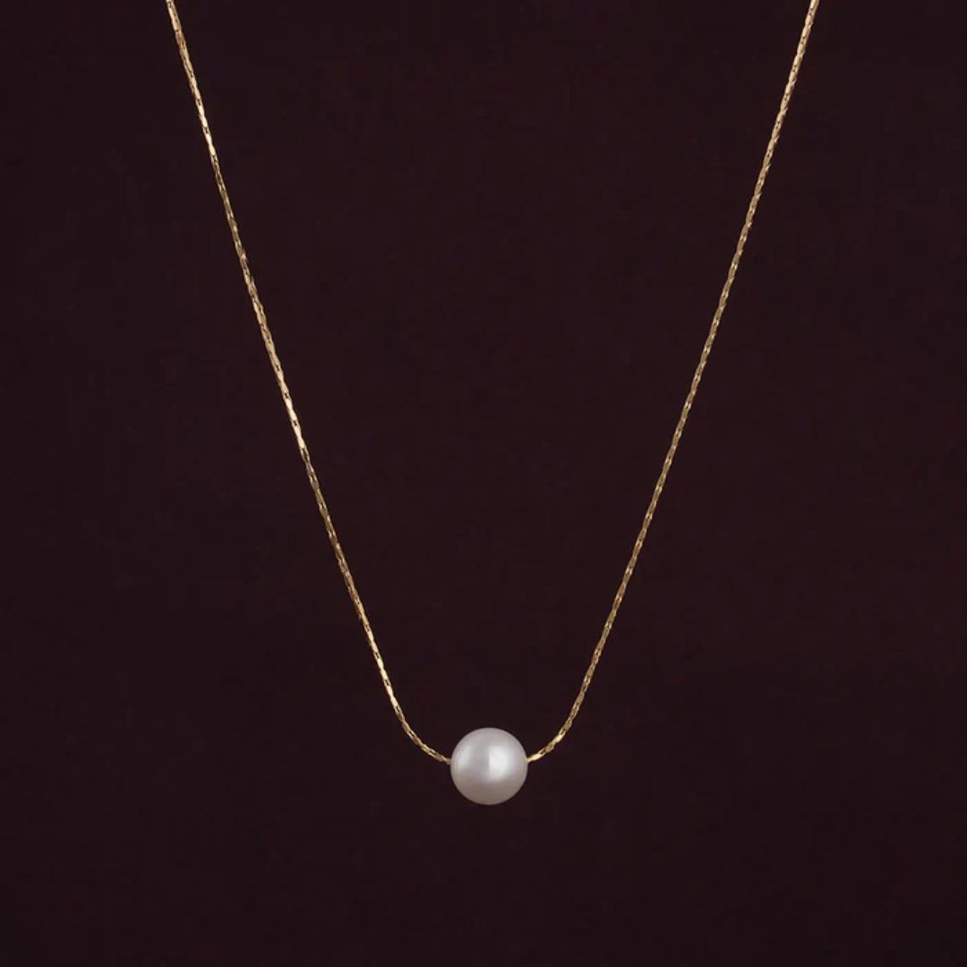 Gold necklace with a single pearl Pendant for Women on a dark background