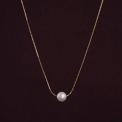 Gold necklace with a single pearl Pendant for Women on a dark background
