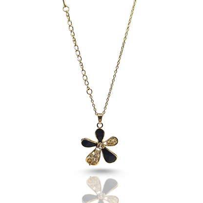 Gold and black flower-shaped pendant on a chain against a white background