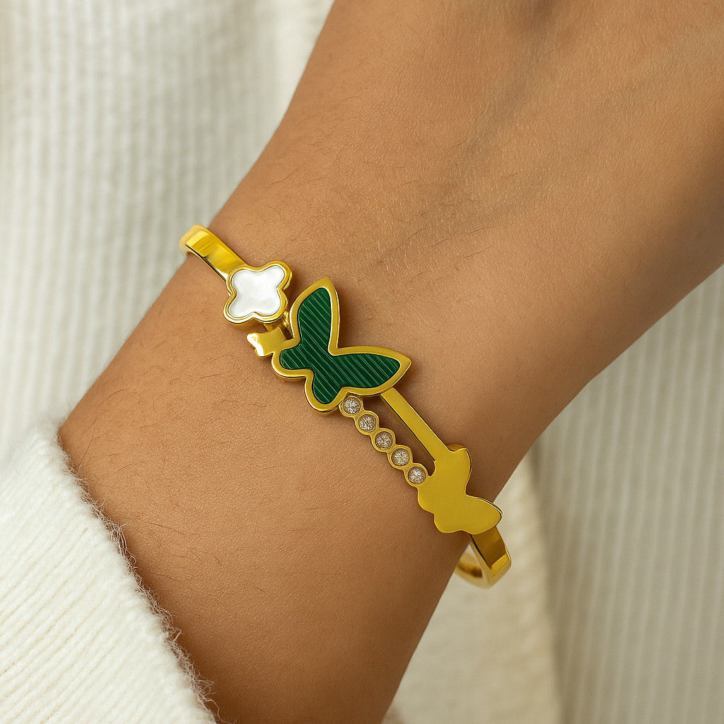Gold plated and green bracelet for women on a wrist with a neutral background